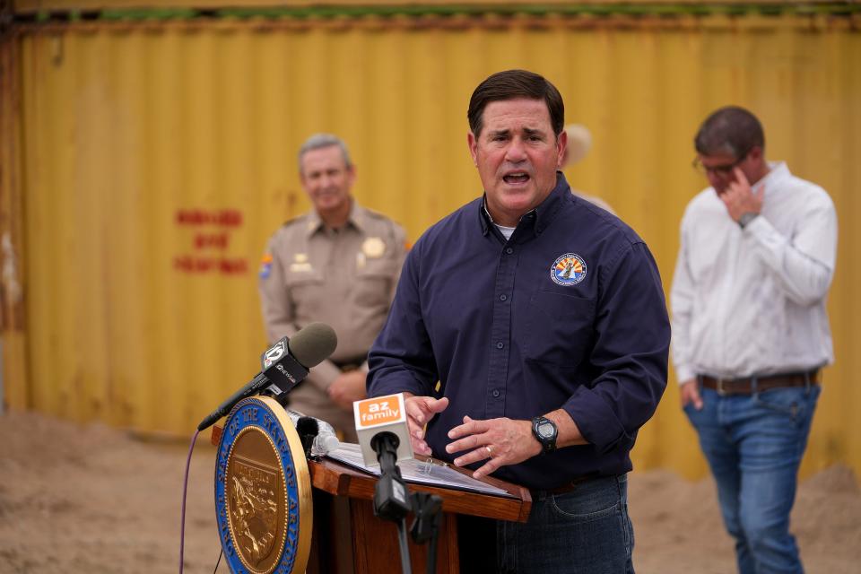 Gov. Doug Ducey answers questions during a news conference in front of a border gap near the Morelos Dam covered by shipping containers on Sept. 8, 2022, near Yuma.