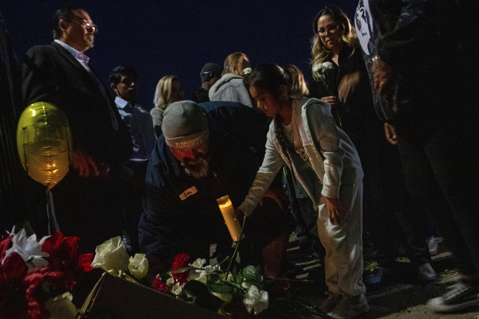 A makeshift memorial for a high school student lines a fence along an alleyway near Rancho High School in eastern Las Vegas on Tuesday, Nov. 21, 2023. Authorities have arrested at least eight students in connection with the beating of Jonathan Lewis Jr., who died a week after a prearranged fight over a pair of headphones and a vape pen. (AP Photo/Ty ONeil)