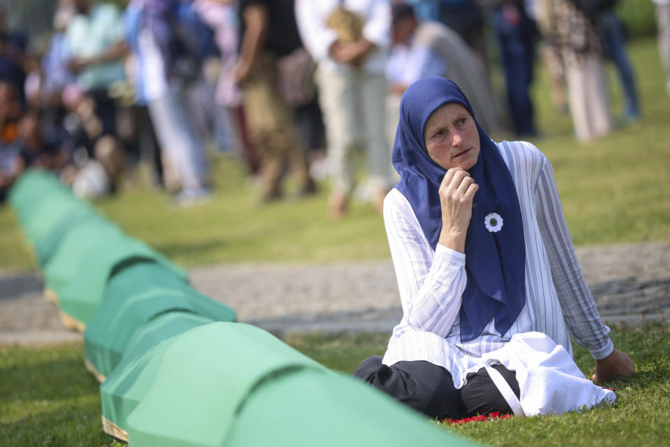 A Bosnian muslim woman mourns next to the coffin contains remains of her relative, victim of the Srebrenica genocide, in Memorial Centre in Potocari, Bosnia, Tuesday, July 11, 2023. Thousands converge on the eastern Bosnian town of Srebrenica to commemorate the 28th anniversary on Monday of Europe's only acknowledged genocide since World War II. (AP Photo/Armin Durgut)