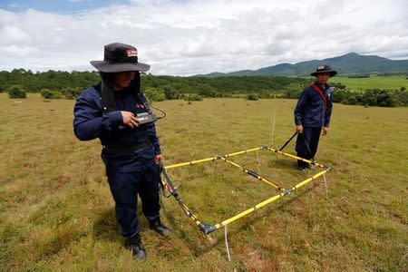 Technicians from the NGO Mines Advisory Group (MAG) work in a field searching for unexploded bombs that were dropped by the U.S. Air Force planes during the Vietnam War, at Phaxay district in Xieng Khouang province, Laos September 2, 2016. REUTERS/Jorge Silva