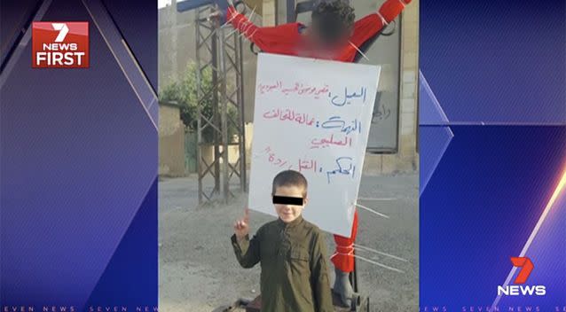 The image shows Khaled Sharrouf's youngest son posing with a dead body. Photo: 7 News