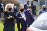 Jill Biden, left, wife of Democratic presidential candidate former vice president Joe Biden, and Doug Emhoff, center, husband of Democratic vice presidential candidate Sen. Kamala Harris, D-Calif., greet supporters in passing cars during a campaign stop, Wednesday, Sept. 16, 2020, in Manchester, N.H. (AP Photo/Steven Senne)