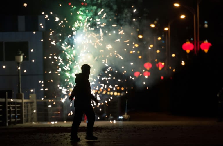 A man sets off fireworks to celebrate the Lunar New Year of the Monkey