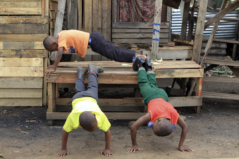 Children use a deserted market stall into an exercise bench as business came to a standstill on the third day of protests over the hike in fuel prices in Harare, Zimbabwe, Wednesday, Jan. 16, 2019. Streets are deserted in Harare on Wednesday as a general strike continues for a third day to protest the government's decision to more than double the price of fuel. (AP Photo/Tsvangirayi Mukwazhi)