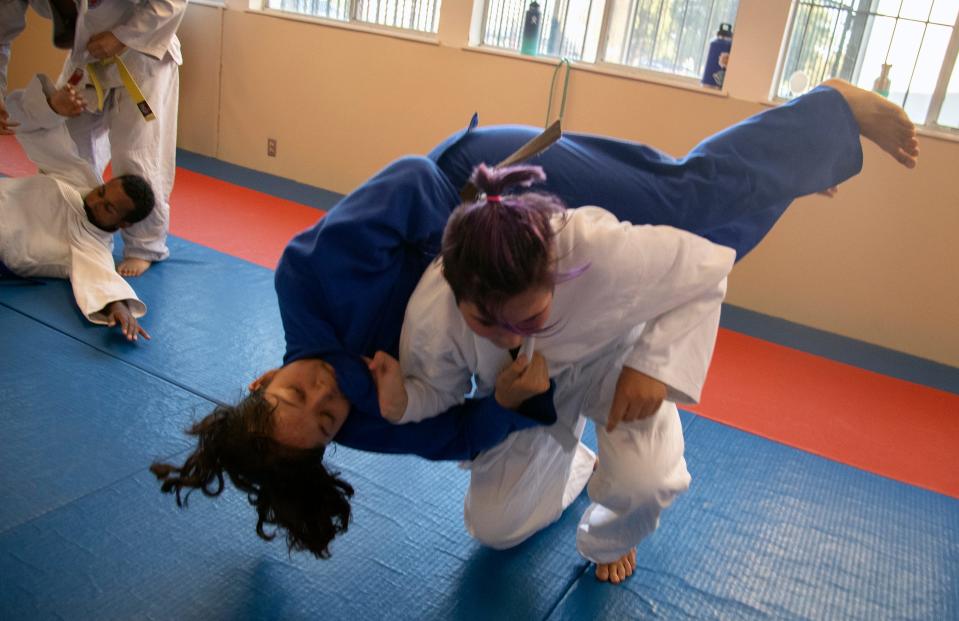 14-year-old Alyx Long, right, flips Alejandra Ochoa, 17, during a practice of the Stockton Judo Club at the McKinley Park Community Center in south Stockton.