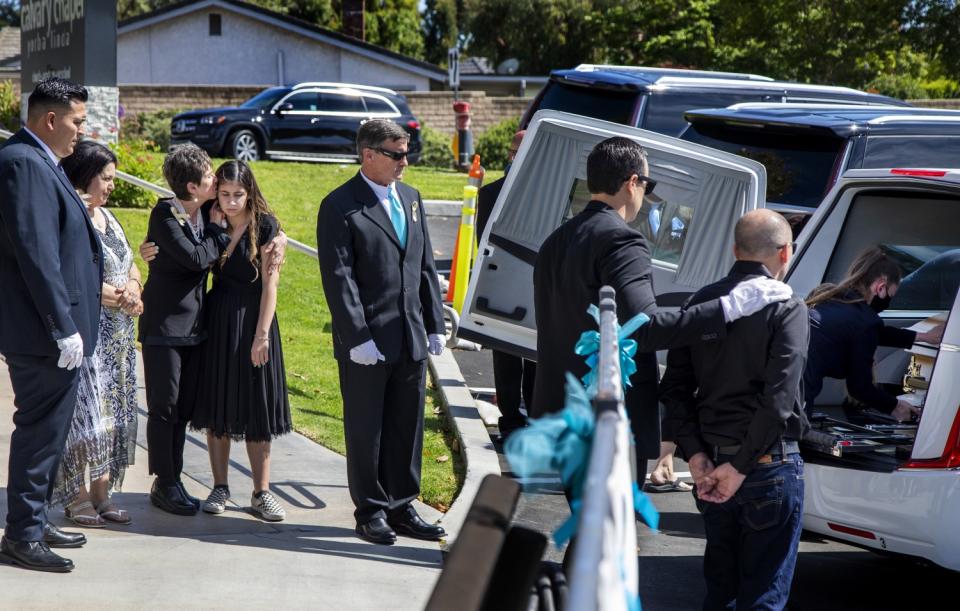 Family members console each other after Aiden Leos' funeral service on Saturday.