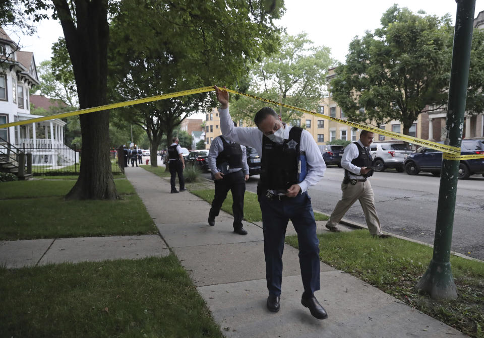Police detectives canvas the area where a 3-year-old boy was fatally shot while riding in an SUV with his father, near the intersection of North Central Avenue and West Huron Street, in the Austin neighborhood Saturday, June 20, 2020, in Chicago. Multiple people, including several children, were killed as more than 100 people were shot in a wave of gunfire in Chicago over the Father’s Day weekend that produced the city’s highest number of shooting victims in a single weekend this year. (John J. Kim/Chicago Tribune via AP)