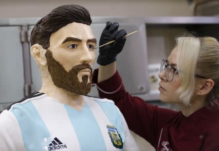An employee of Altufyevo Confectionery finishes the preparation of a life-size chocolate sculpture of Argentine soccer player Lionel Messi to top a cake for the celebration of his upcoming birthday in Moscow, a host city for the World Cup, Russia June 23, 2018. REUTERS/Tatyana Makeyeva
