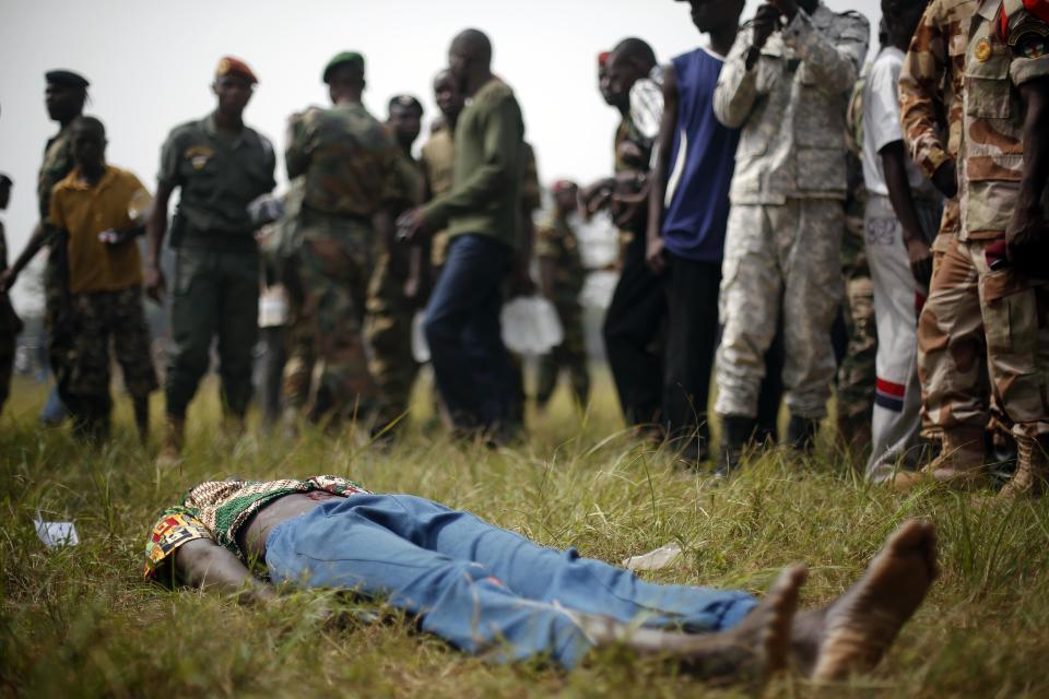 A man suspected to be a Muslim Seleka militiaman lays wounded after being stabbed by newly enlisted FACA (Central African Armed Forces) soldiers moments after Central African Republic Interim President Catherine Samba-Panza addressed the troops in Bangui Wednesday Feb. 5, 2014. The man died later after being lynched by hundreds of recruits using knifes, bricks and foot blows to the head. (AP Photo/Jerome Delay)