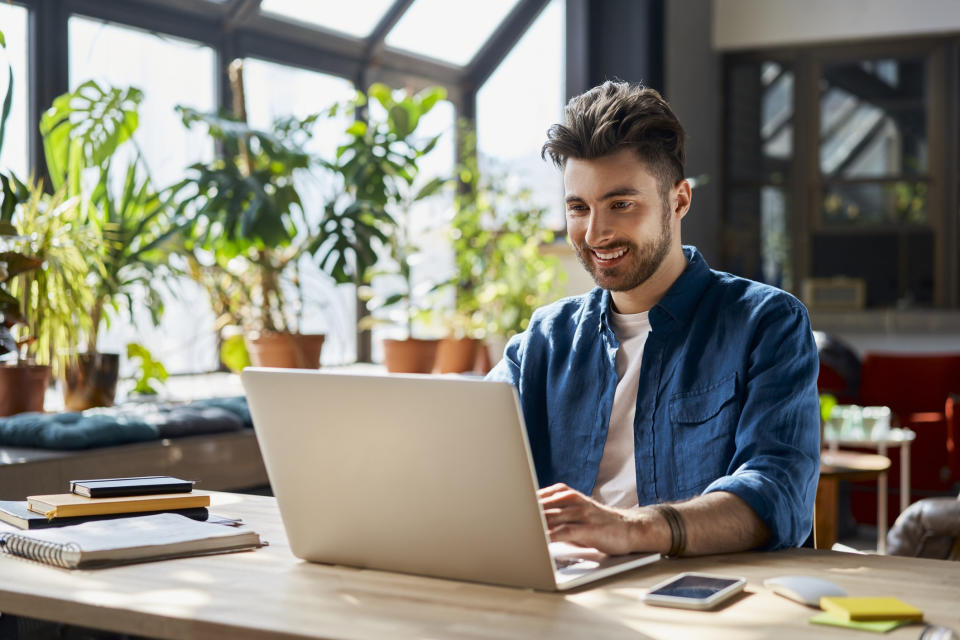 a man smiling and looking at a computer