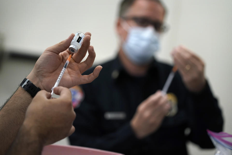 FILE - In this Feb. 10, 2021, file photo, people prepare doses of a COVID-19 vaccine at the Martin Luther King Senior Center, in North Las Vegas. Nevada health officials are reporting about one in six people statewide has received at least a first dose of a COVID-19 vaccine since shots became available in mid-December. Washoe County coronavirus response official James English told reporters Monday, March 8, 2021, to expect vaccinations to "ramp up" during the next couple of weeks. (AP Photo/John Locher,File)