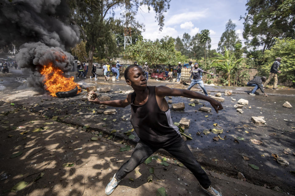 A protester throws rocks towards police in the Kibera slum of Nairobi, Kenya, Monday, March 20, 2023. Hundreds of opposition supporters have taken to the streets of the Kenyan capital over the result of the last election and the rising cost of living, in protests organized by the opposition demanding that the president resigns from office. (AP Photo/Ben Curtis)