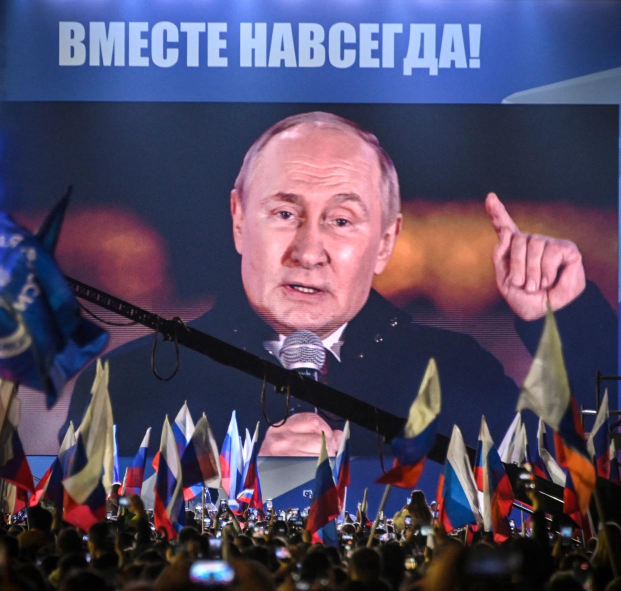 Russian President Vladimir Putin is seen on a screen set at Red Square as he addresses a rally and a concert marking the annexation of four regions of Ukraine Russian troops occupy - Lugansk, Donetsk, Kherson and Zaporizhzhia, in central Moscow on September 30, 2022. (Photo by Alexander NEMENOV / AFP) (Photo by ALEXANDER NEMENOV/AFP via Getty Images)