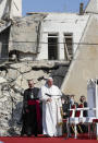 Pope Francis, surrounded by shells of destroyed churches, attends a prayer for the victims of war at Hosh al-Bieaa Church Square, in Mosul, Iraq, once the de-facto capital of IS, Sunday, March 7, 2021. The long 2014-2017 war to drive IS out left ransacked homes and charred or pulverized buildings around the north of Iraq, all sites Francis visited on Sunday. (AP Photo/Andrew Medichini)