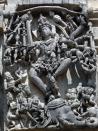 The scene is called Gajasura Samhara.Lord Shiva, in one of his furious forms- Gajasura Mardana, is dancing on the head of Gajasura, the elephant demon, and ripping off his skin. Observe the ripped skin above Shiva's head.