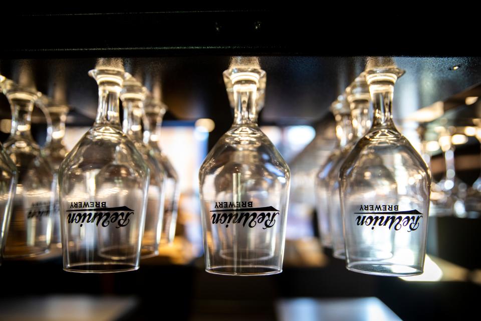 ReUnion Brewery glasses are seen displayed at a bar Sept. 22. The new location will have three levels, with bars on each.