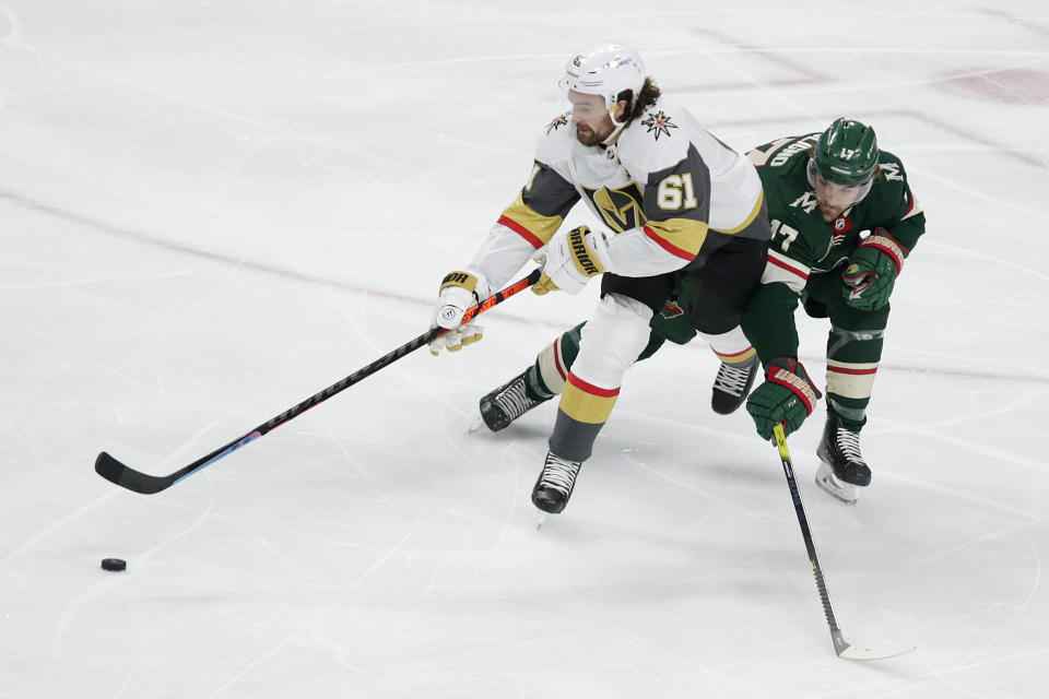Vegas Golden Knights right wing Mark Stone (61) controls the puck next to Minnesota Wild left wing Marcus Foligno (17) during the first period in Game 6 of an NHL hockey Stanley Cup first-round playoff series Wednesday, May 26, 2021, in St. Paul, Minn. (AP Photo/Andy Clayton-King)