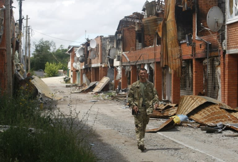 A Ukrainian serviceman walks past destroyed houses in Shyrokyne, Donetsk region, on June 29, 2015