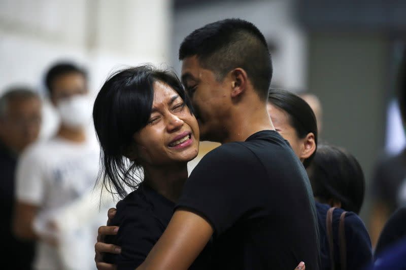 Son and daughter of Captain Siriwiwat Sangprasita, a victim of a gun battle involving a Thai soldier on a shooting rampage, cry after seeing his dead body at a hospital in Nakhon Ratchasima