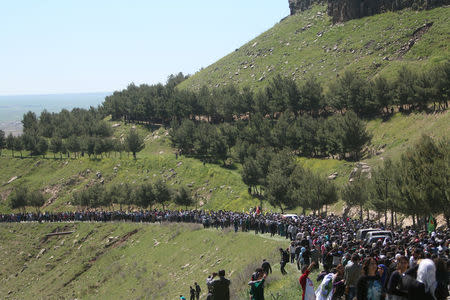 People gather near the headquarters of the Kurdish People's Protection Units (YPG) after it was hit by Turkish airstrikes in Mount Karachok near Malikiya, Syria. REUTERS/ Rodi Said