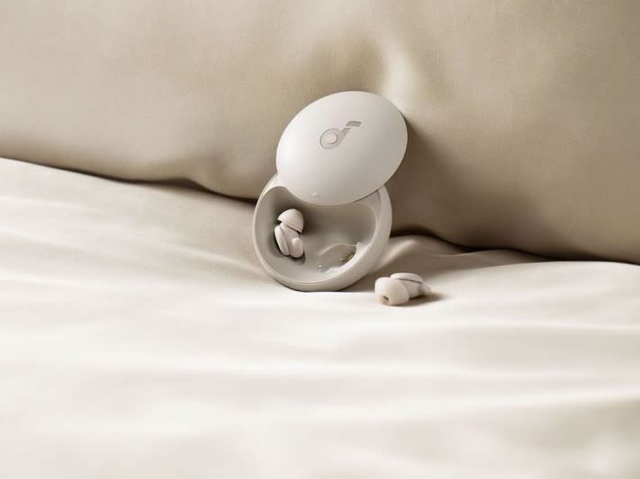 Anker Soundcore Sleep A20 earbuds with wireless charging case on bed