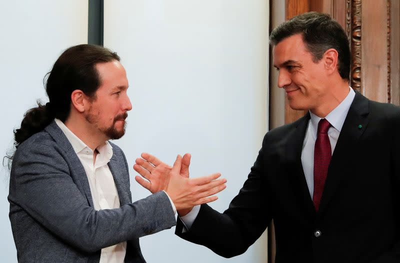 FOTO DE ARCHIVO: El presidente del Gobierno de España, Pedro Sánchez, y el líder de Unidas Podemos, Pablo Iglesias, se dan la mano al presentar su acuerdo de coalición en el Congreso en Madrid, España, el 30 de diciembre de 2019