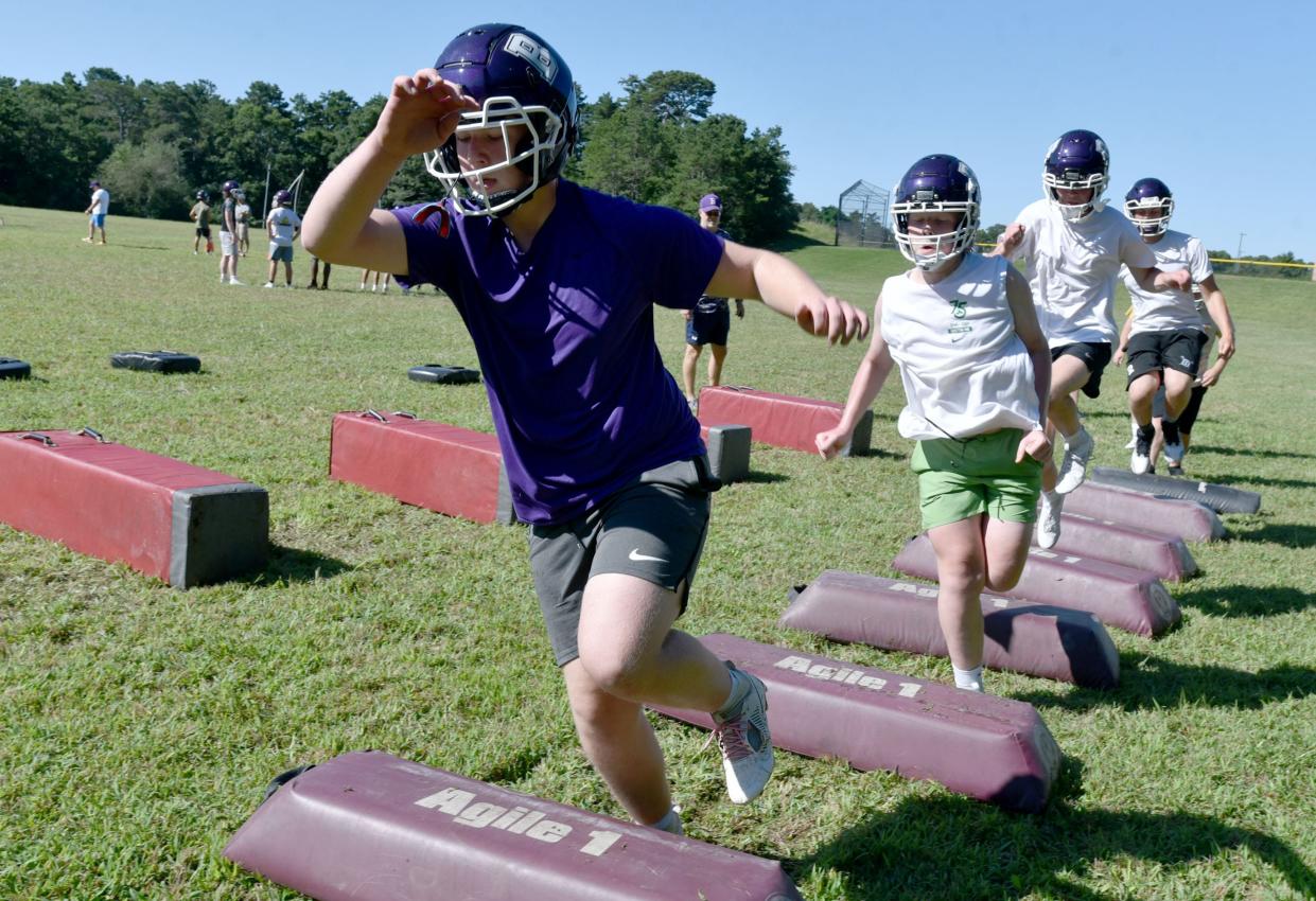 Caden Doherty, left, takes on an agility drill during a Saturday morning early season workout on the school's practice field for the Bourne football squad.