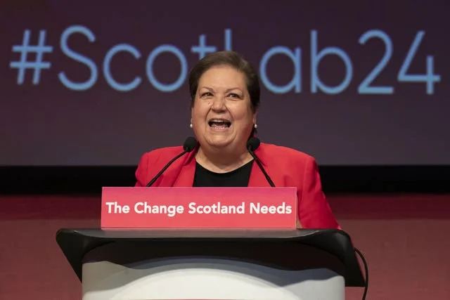 Dame Jackie Baillie speaking from a lectern reading 'The change Scotland needs'