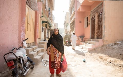 Naseem, 55, poses for a family portrait near her family home located in Al-Noor Housing Society in Karachi on December 5, 2018. A housewife and a mother of two daughters who are both married, Naseem finds it particularly hard to afford the monthly two tankers that cost her at least 5000 Pakistani rupees.  - Credit: Insiya Syed/The Telegraph