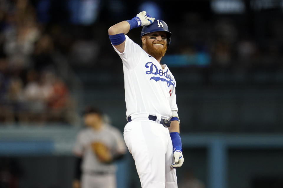 Los Angeles Dodgers' Justin Turner taps his helmet as he stands on second base after driving in two runs with a double during the third inning of a baseball game against the San Francisco Giants Thursday, July 21, 2022, in Los Angeles. (AP Photo/Marcio Jose Sanchez)