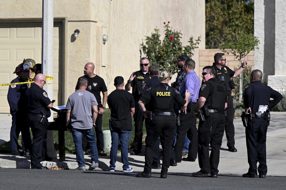 Firefighters and Riverside Police gather outside a burned home in Riverside, Calif., on Friday, Nov. 25, 2022 following a house fire. Three bodies were found in the house which police are investigating as a homicide. (Will Lester/Inland Valley Daily Bulletin/SCNG via AP)