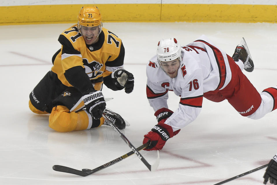 APTOPIX-Carolina Hurricanes' Brady Skjei (76) dives to control, the pouch in front of Pittsburgh Penguins' Evgeni Malkin (71) during the first period of an NHL hockey game, Sunday, March 8, 2020, in Pittsburgh. (AP Photo/Keith Srakocic)
