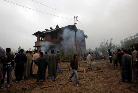 People gather outside a residential house that was damaged during a gun battle between Zakir Rashid Bhat also known as Zakir Musa, the leader of an al Qaeda affiliated militant group in Kashmir, and Indian security forces in Dadasara village in south Kashmir's Tral May 24, 2019. REUTERS/Danish Ismail