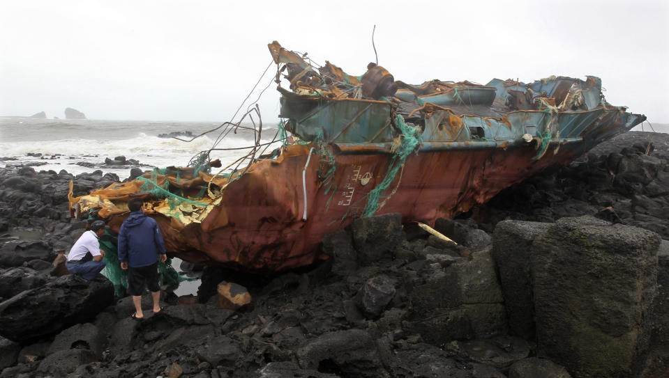 Wreckage of a Chinese ship sits on the shore after it slammed into rocks off the southern coast in Jeju, South Korea, Tuesday, Aug. 28, 2012. A powerful typhoon pounded South Korea with strong winds and heavy rain Tuesday, while the nation's coast guard battled rough seas in a race to rescue fishermen on two Chinese ships that slammed into rocks off the southern coast. (AP Photo/Yonhap, Kim Ho-chun) KOREA OUT