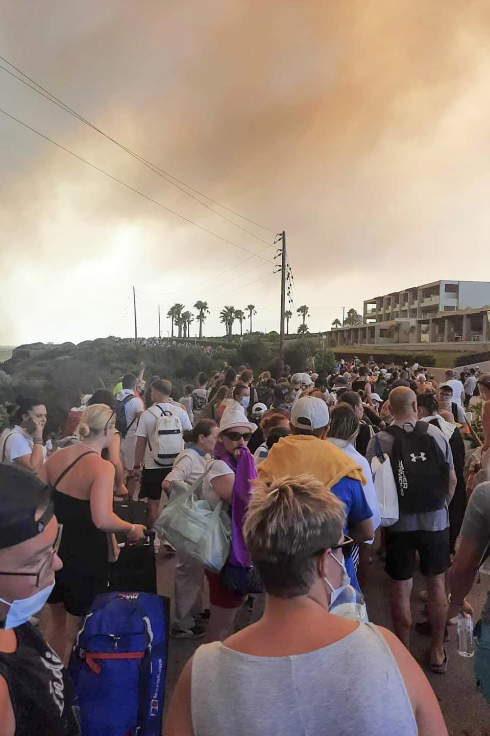 Tourists are being evacuated during a forest fire on the island of Rhodes, Greece, Saturday, July 22, 2023. A large blaze burning on the Greek island of Rhodes for the fifth day has forced authorities to order an evacuation of four locations, including two seaside resorts. (Rhodes.Rodos via AP)