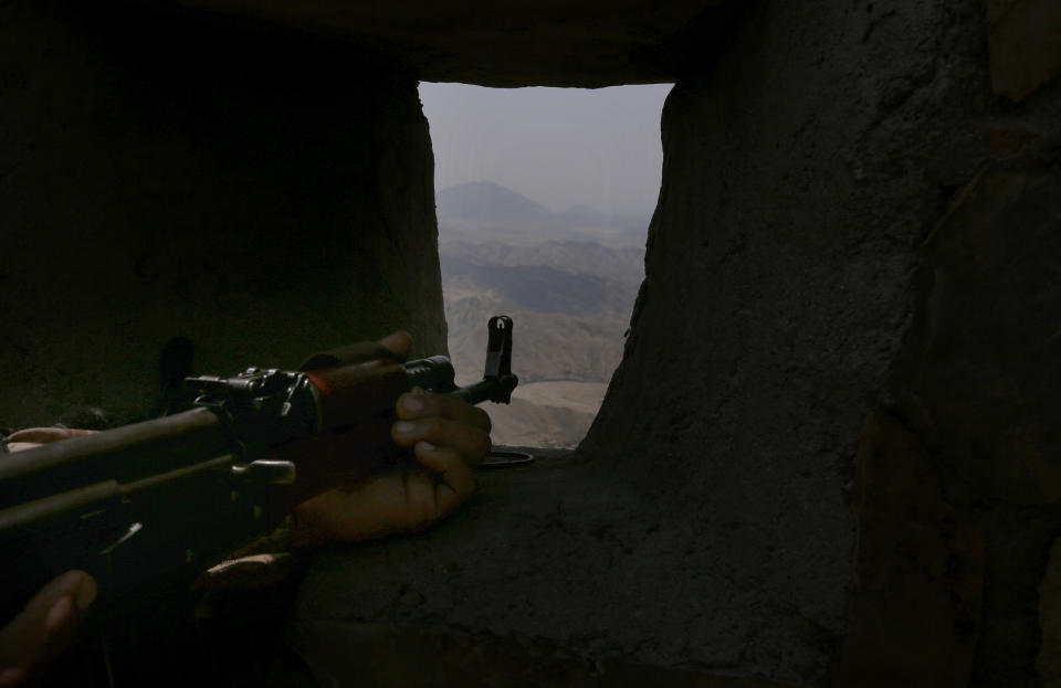 A Pakistan Army soldier observes the area from hilltop post on the Pakistan Afghanistan, in Khyber district, Pakistan, Tuesday, Aug. 3, 2021. Pakistan's military said it completed 90 percent of the fencing along the border with Afghanistan, vowing the remaining one of the most difficult tasks of improving the border management will be completed this summer to prevent any cross-border militant attack from both sides. (AP Photo/Anjum Naveed)