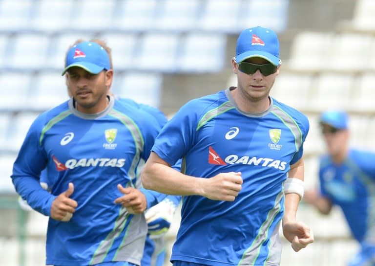 Australia's captain Steven Smith (R) and teammates warm up during a practice session at the Pallekele International Cricket Stadium in Sri Lanka, on July 23, 2016