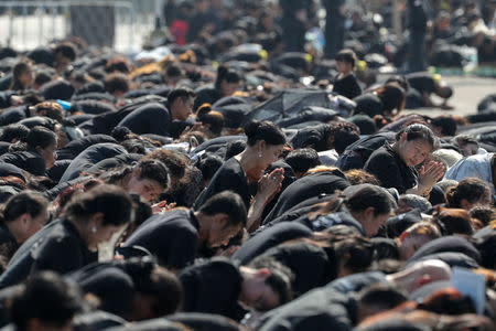 People pray during a procession to transfer the royal relics and ashes of Thailand's late King Bhumibol Adulyadej from the crematorium to the Grand Palace in Bangkok, Thailand, October 27, 2017. REUTERS/Athit Perawongmetha