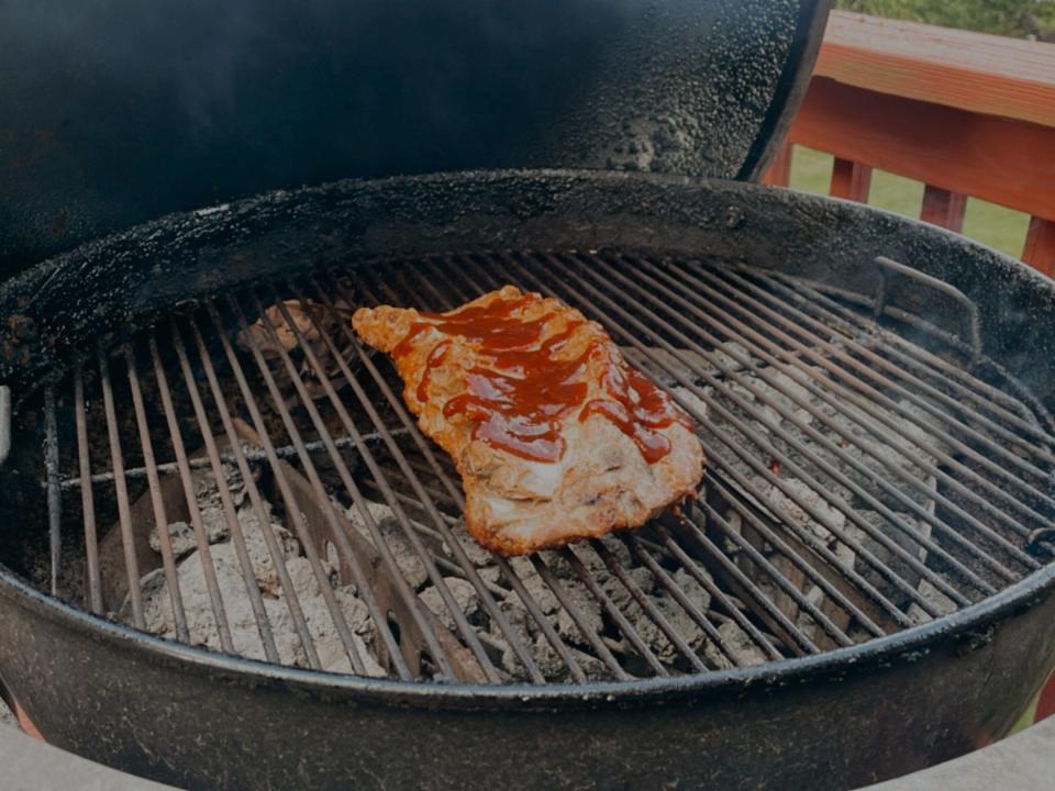 ribs on the grates of a charcoal grill