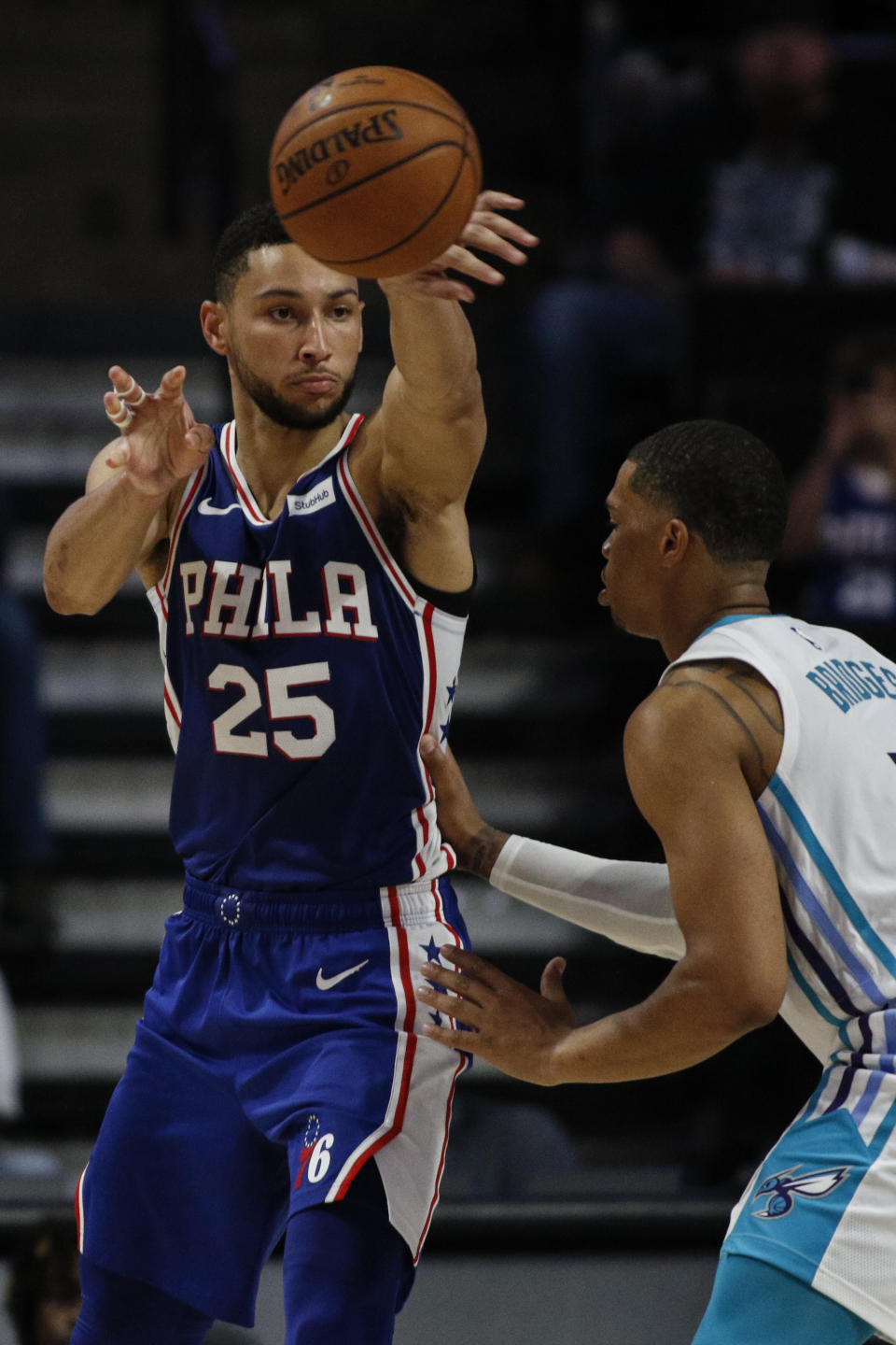 Philadelphia 76ers guard Ben Simmons, left, passes around Charlotte Hornets forward Miles Bridges in the second half of a preseason NBA basketball game in Winston-Salem, N.C., Friday, Oct. 11, 2019. (AP Photo/Nell Redmond)