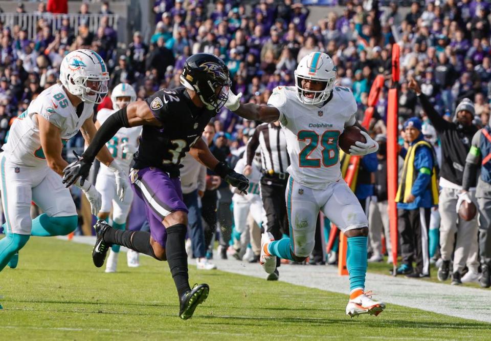 El running back de los Dolphins de Miami De’Von Achane (28) corre con el ovoide ante la marca del safety de los Ravens Marcus Williams (centro) en el partido celebrado el 31 de diciembre de 2023 en Baltimore.