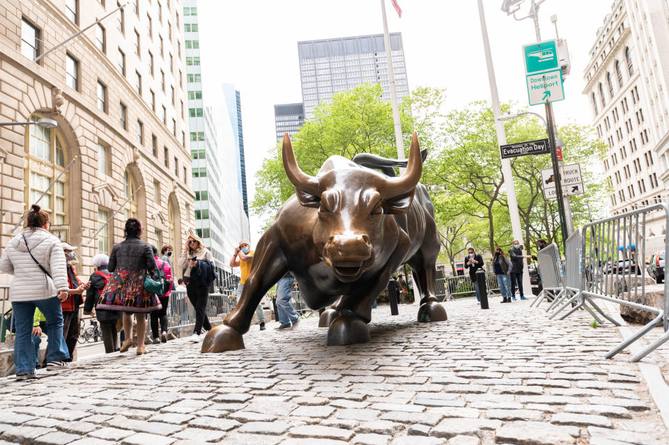 NEW YORK, NEW YORK - MAY 11: People visit the Charging Bull statue in Wall Street on May 11, 2021 in New York City. New York Governor Andrew Cuomo announced pandemic restrictions to be lifted on May 19.  (Photo by Noam Galai/Getty Images)