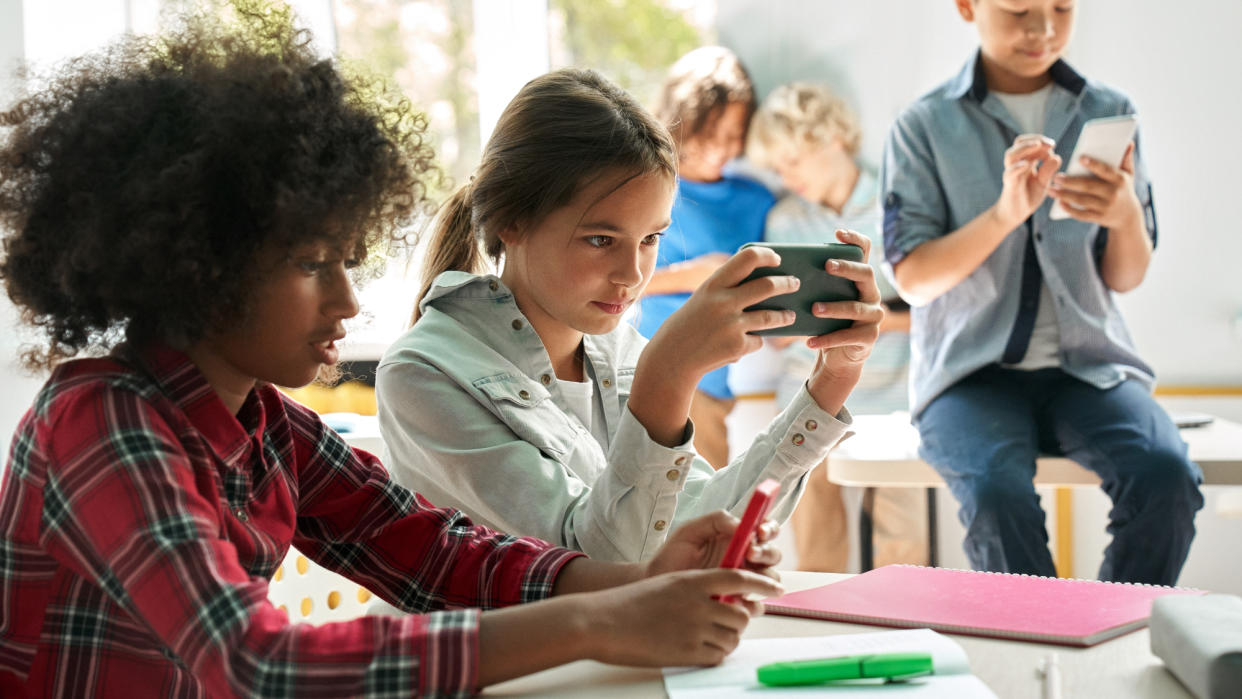  Young kids using smartphones in a classroom setting 