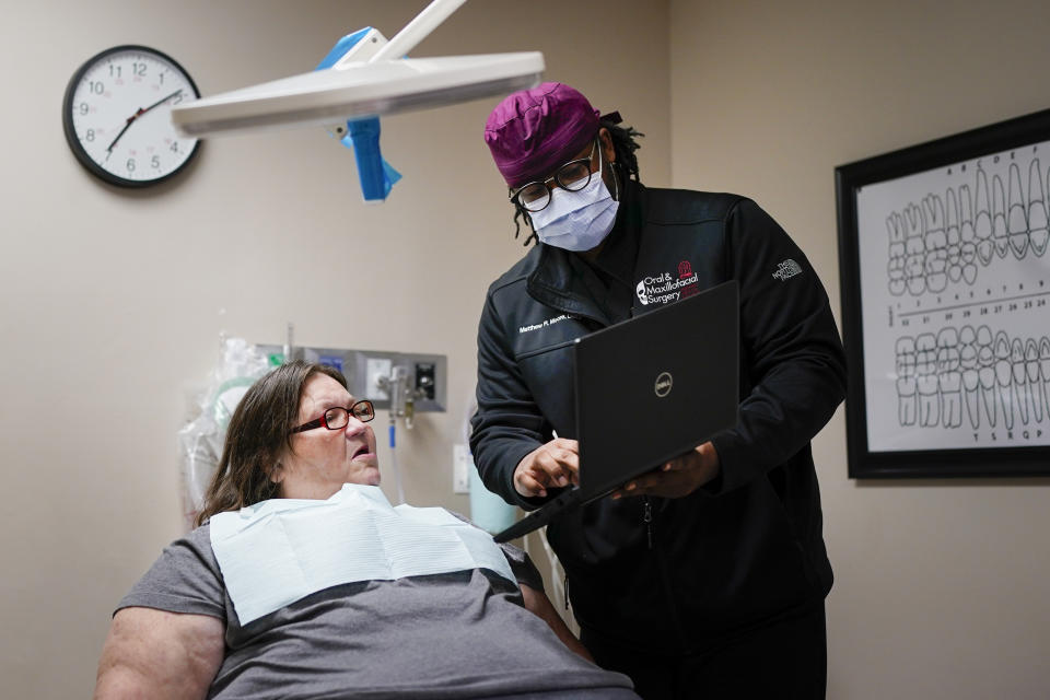 Cindy Clemons, left, discusses her treatment plan with Meharry Medical College School of Dentistry oral surgery resident Matthew Moore during a surgical visit Tuesday, Sept. 12, 2023, in Nashville, Tenn. Clemons was able to receive dental care after an expansion of the state's Medicaid program. (AP Photo/George Walker IV)