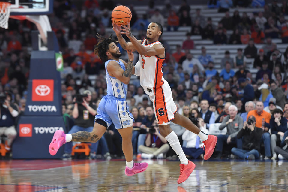 Syracuse guard Judah Mintz, right, reaches for a pass against North Carolina guard RJ Davis during the first half of an NCAA college basketball game in Syracuse, N.Y., Tuesday, Feb. 13, 2024. (AP Photo/Adrian Kraus)