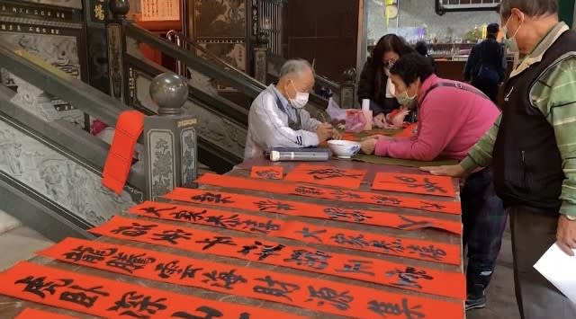 基隆四大古寺慈雲寺臘月十五邀請名家揮毫免費送春聯，慈雲寺主委李林寶玉手持紅紙窗花喜氣洋洋洋。(記者王慕慈攝)