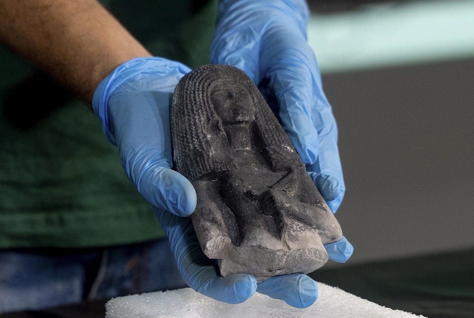 A limestone statue, know as "Dame of the Cone", dated approximately 1307-1196 B.C., is presented to the media by the National Museum during a news conference in Rio de Janeiro, Brazil, Tuesday, May 7, 2019. Brazil's national museum said Tuesday it has recovered 200 pieces from its 700 pieces Egypt collection, the largest in Latin America, after a devastating fire in September 2018. (AP Photo/Lucas Dumphreys).