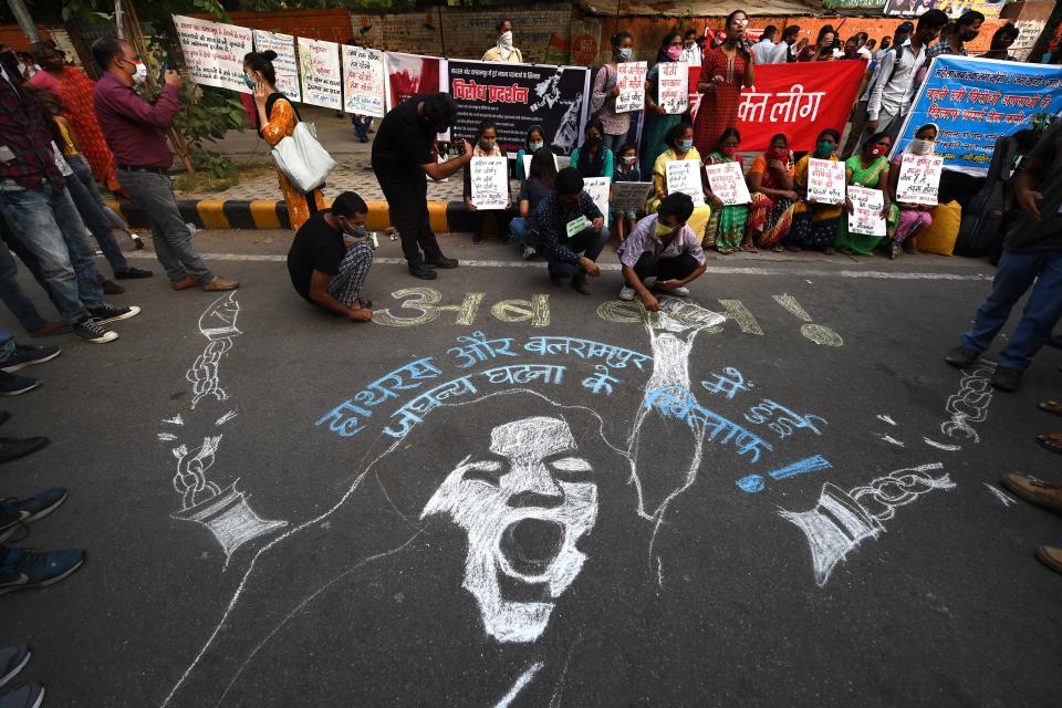 <p>Demonstrators paint a floor mural as they protest against the alleged gang-rape and murder of a 19-year-old woman in Uttar Pradesh state</p> (Getty)