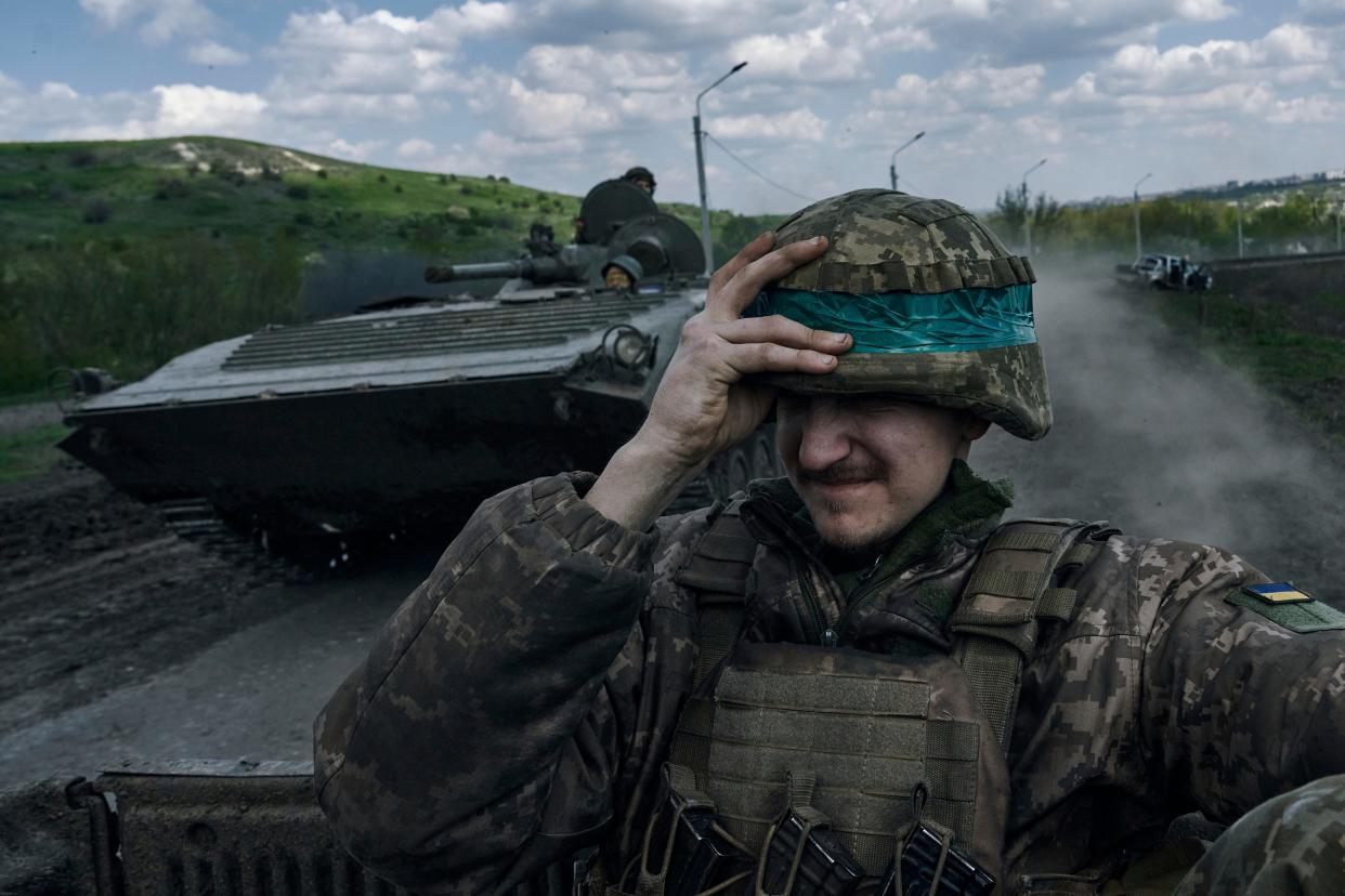 A Ukrainian soldier holds his helmet as he rides an APC in Bakhmut, in the Donetsk region, Ukraine, Wednesday, April 26, 2023. (AP Photo/Libkos) (AP)