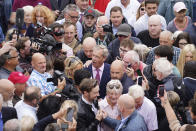 Leader of Reform UK Nigel Farage, center, is surrounded by a crowd as he departs the launch of his General Election campaign at Clacton-on-Sea, England, Tuesday, June 4, 2024. (James Manning/PA via AP)